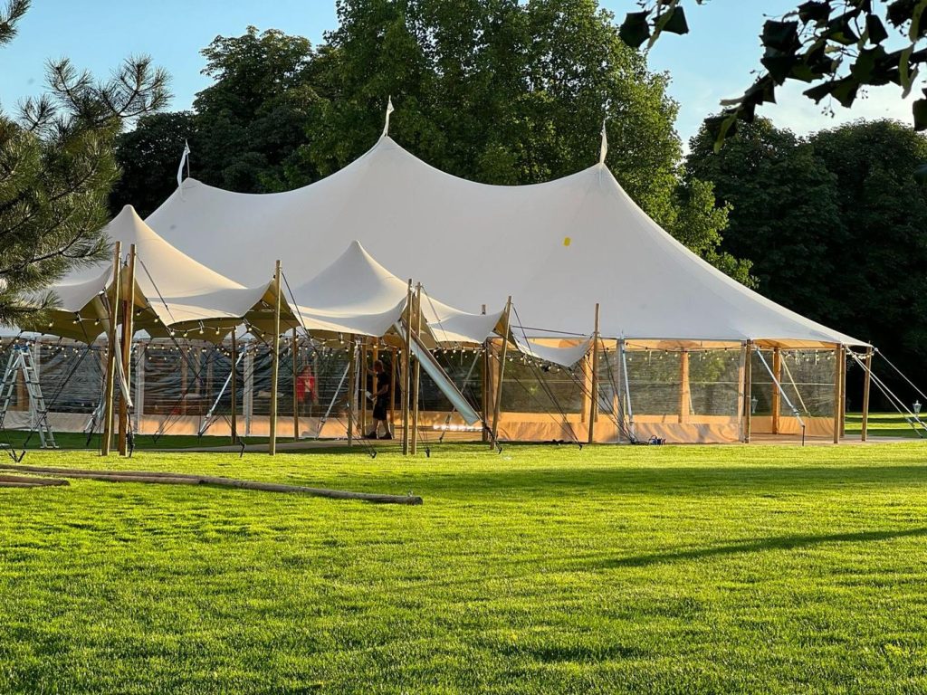 Sailcloth-Zelt Komplettaufbau mit Lichterketten auf einer Wiese, GS EVENTS Zeltverleih